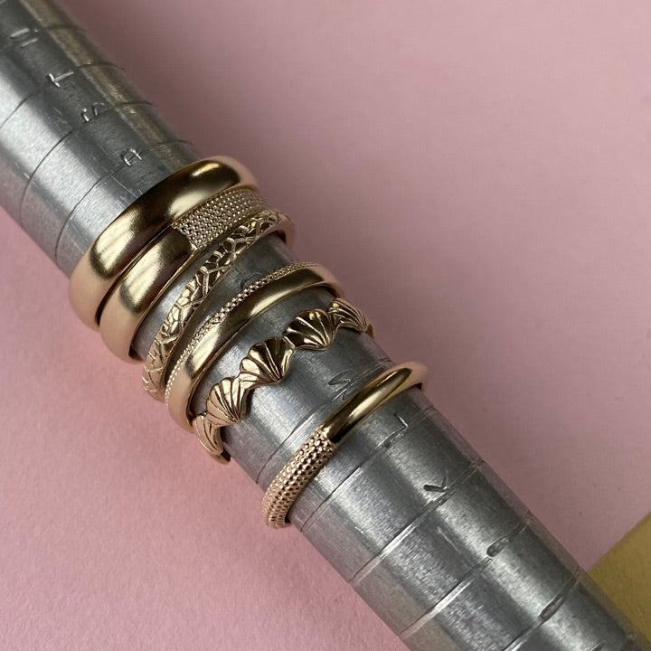 Gold rings on incremented metallic sizing gauge 