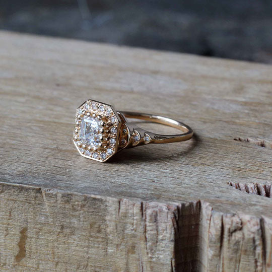 Large square diamond engagement ring on wooden bench