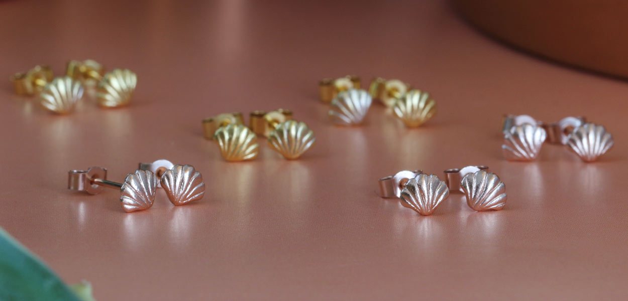 A collection of little rose gold, yellow gold and sterling silver stud earrings for women with shell motif