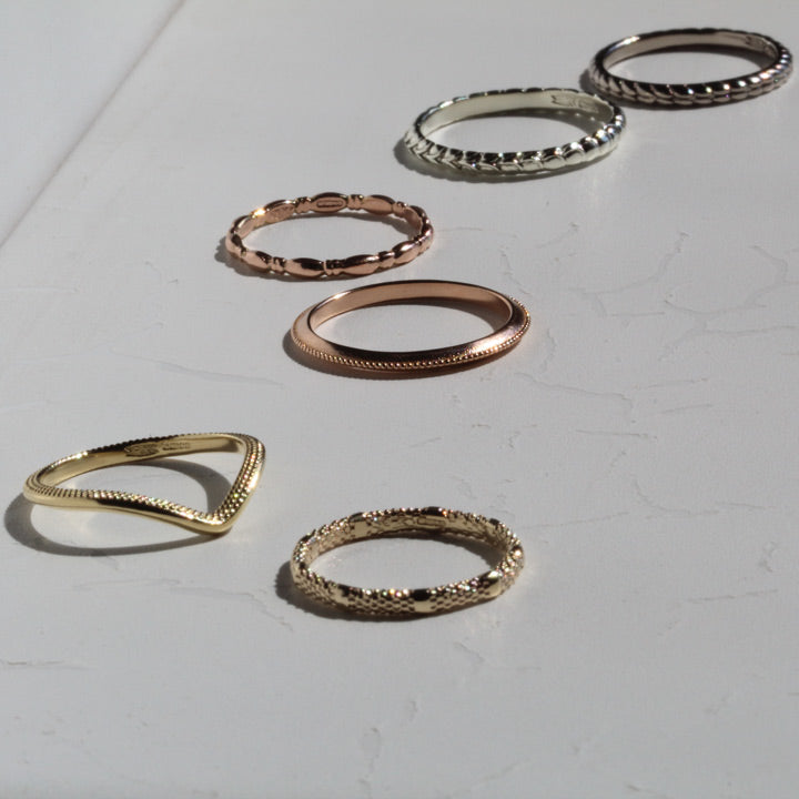 a scattering of yellow, pink and white gold patterned wedding rings.