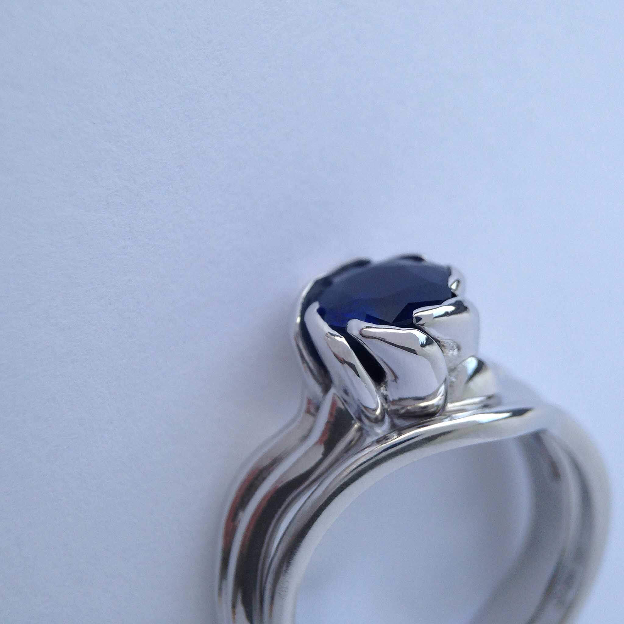 Organic asymetric engagement ring in platinum with dark blue sapphire
