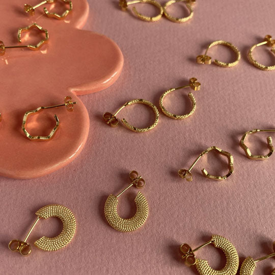 Handmade earrings from ethically sourced materials on pink background
