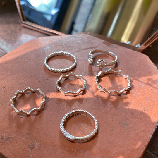 Six sterling silver rings on terracotta slab