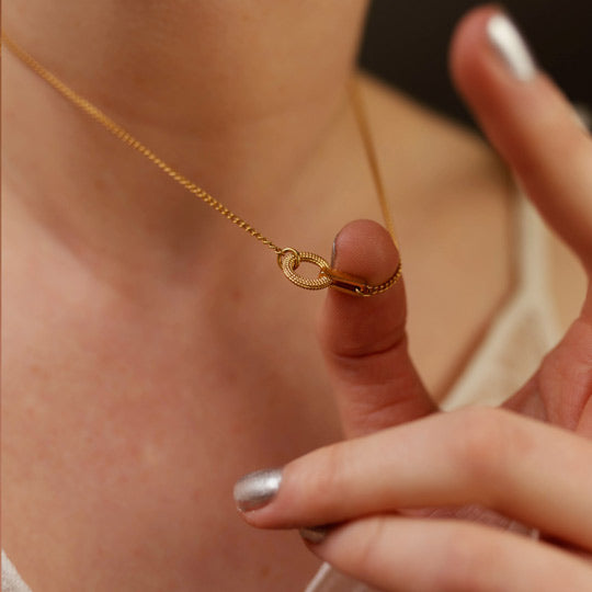Inline tyro short necklace held between fingers