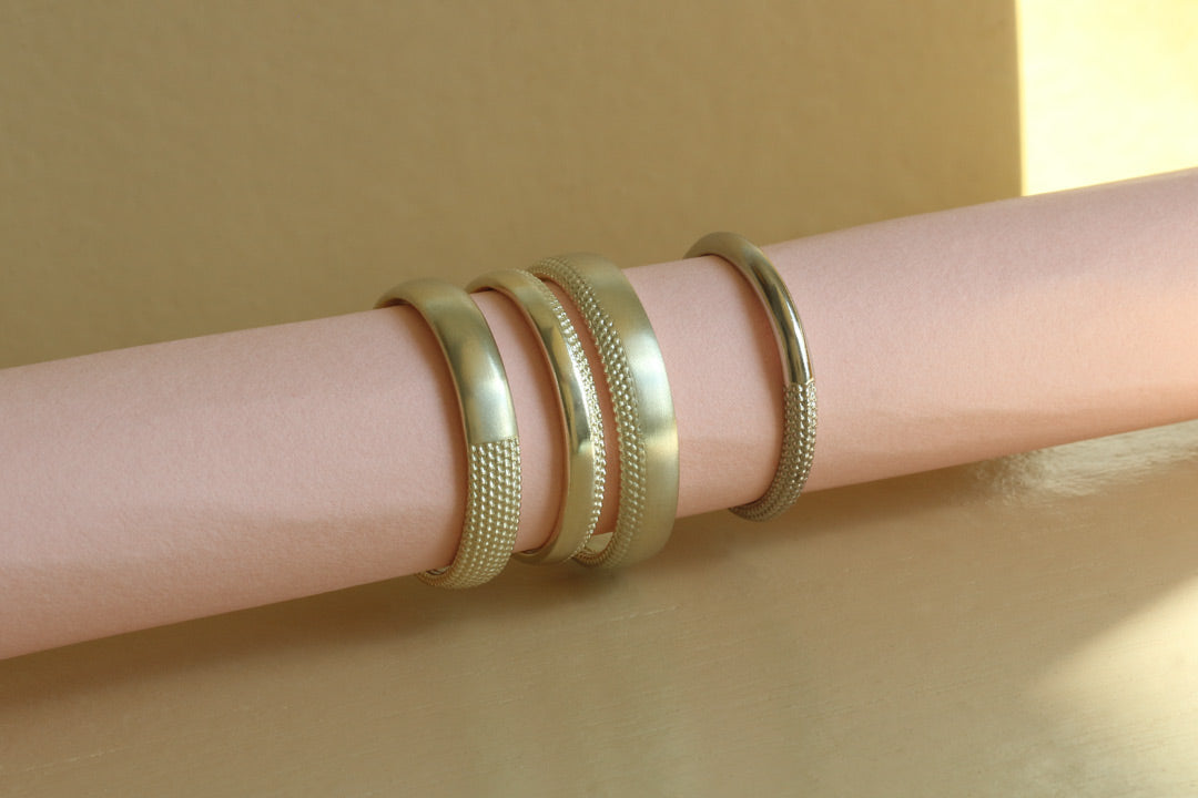 wide unisex textured wedding rings on a roll of pink paper