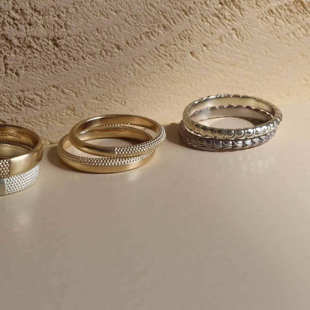 Stacks of solid gold rings with intriguing textures