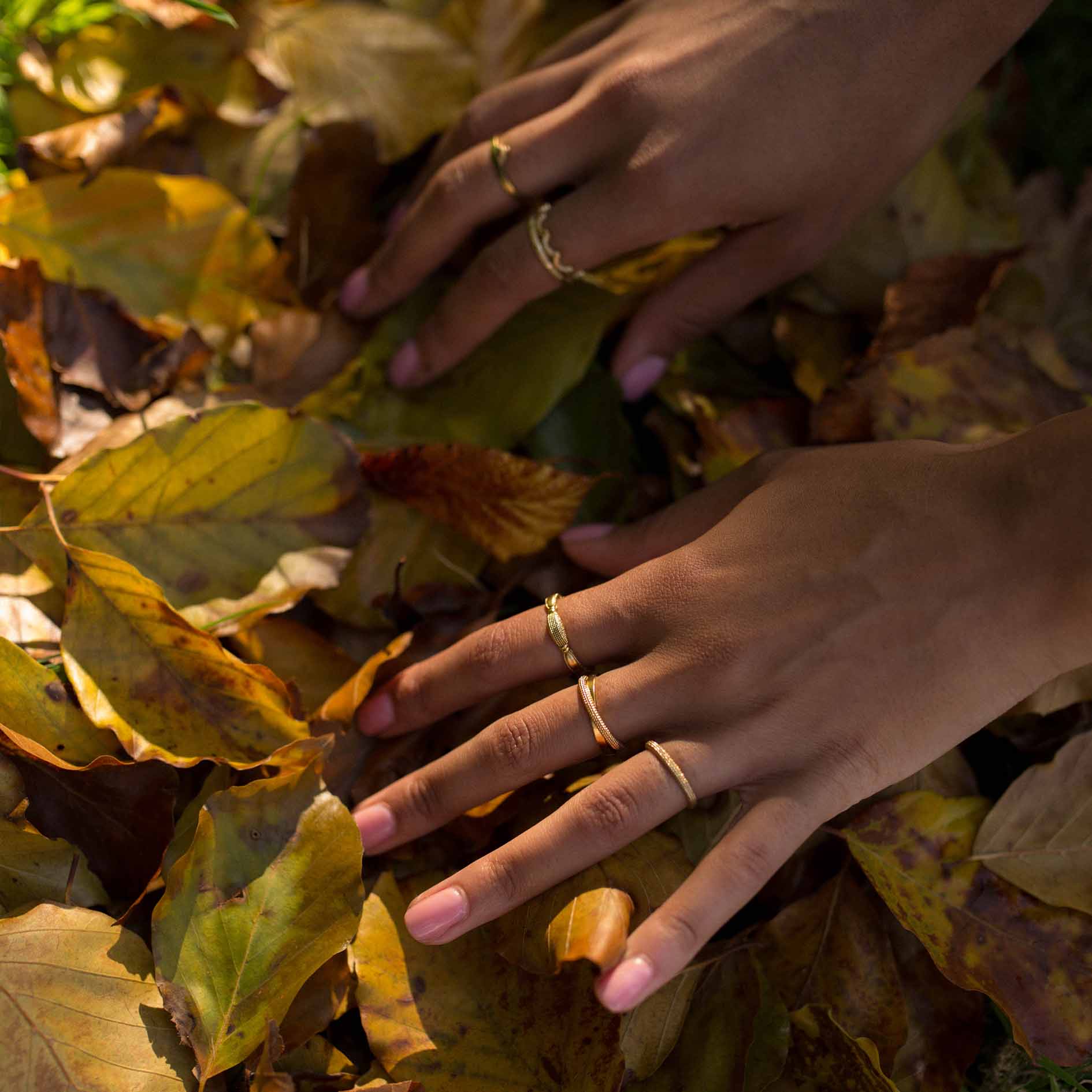 A model rummaging through the leaves wearing a gold rings. 