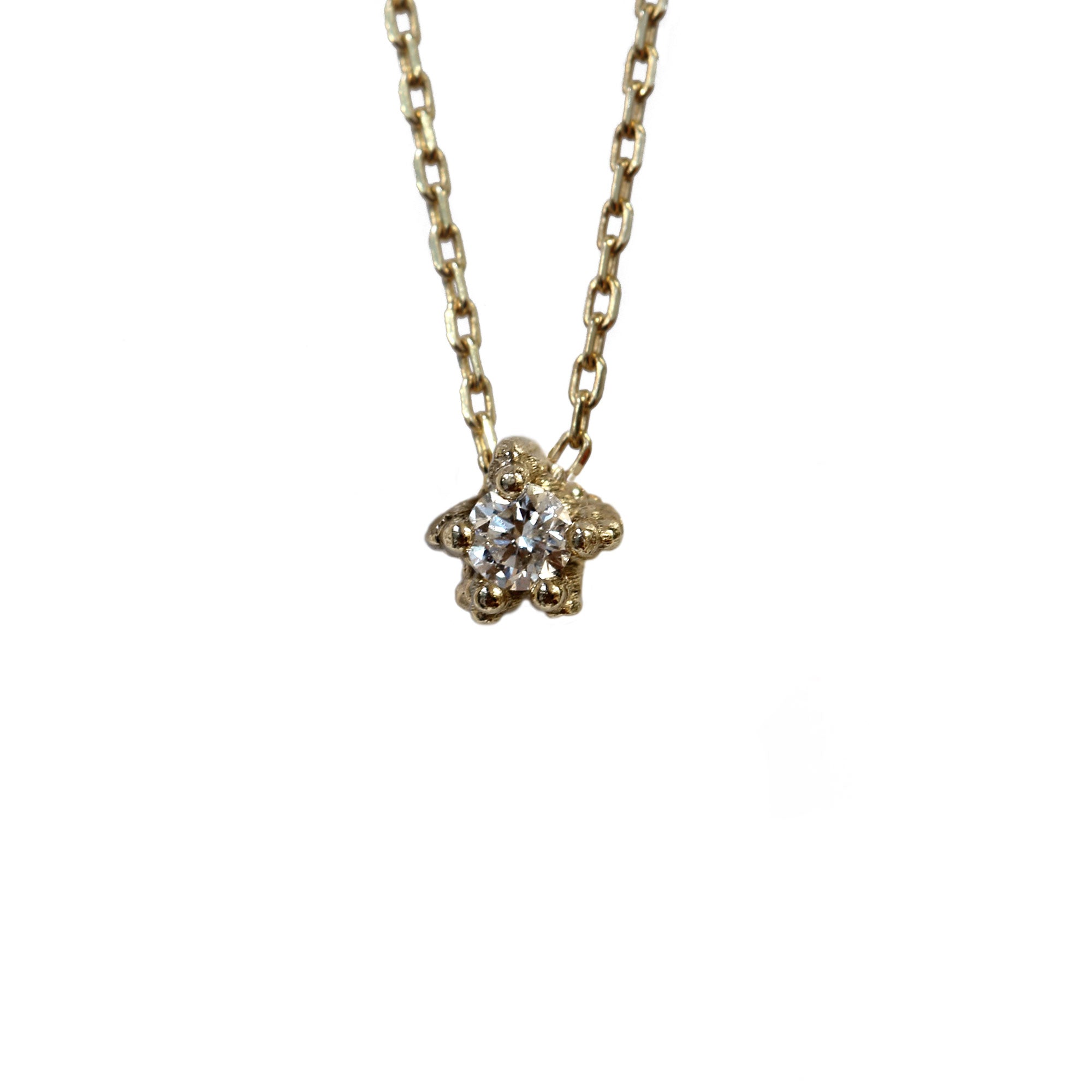 Tiny diamond set textured gold necklace on white background