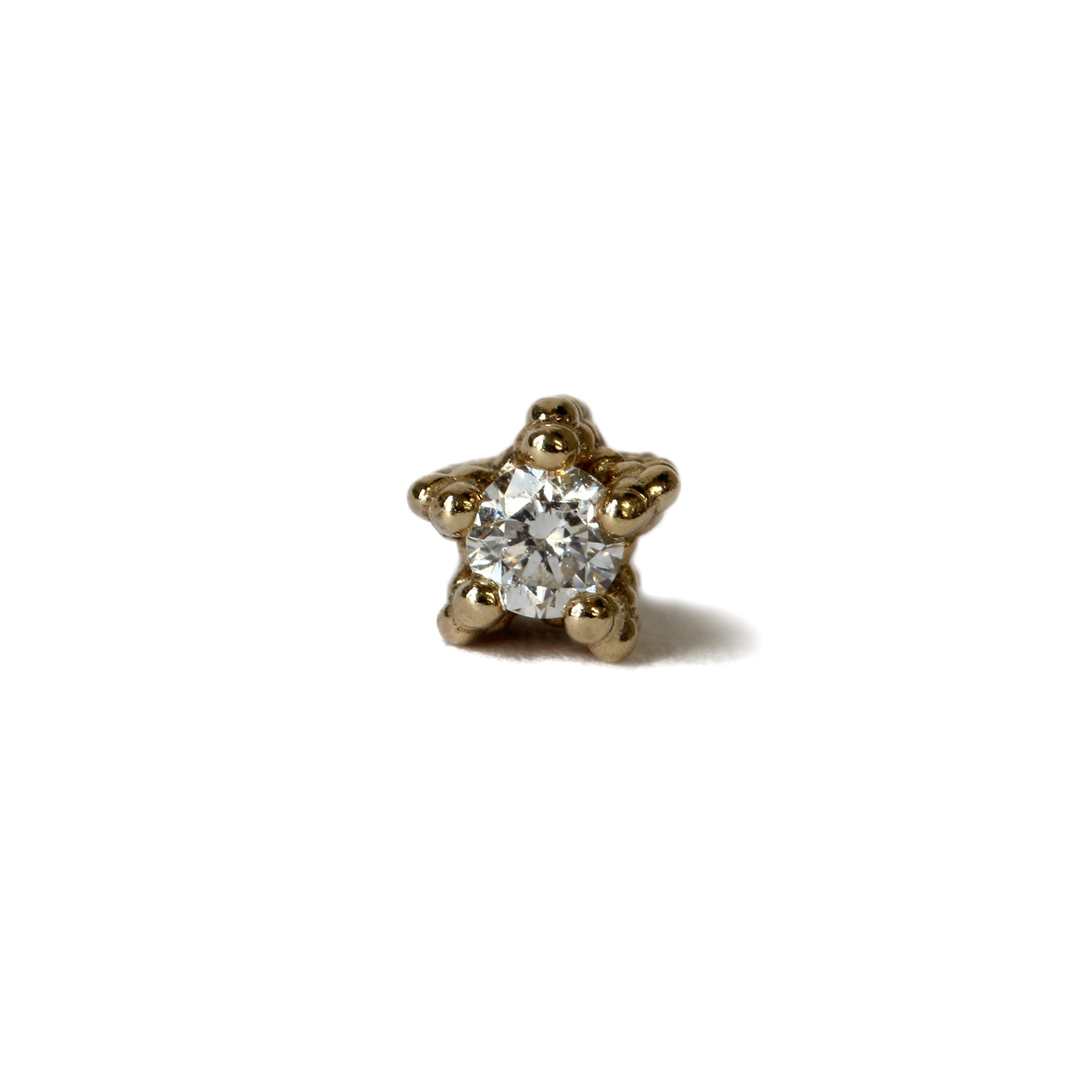 Brilliant cut diamond set in textured gold setting on white background