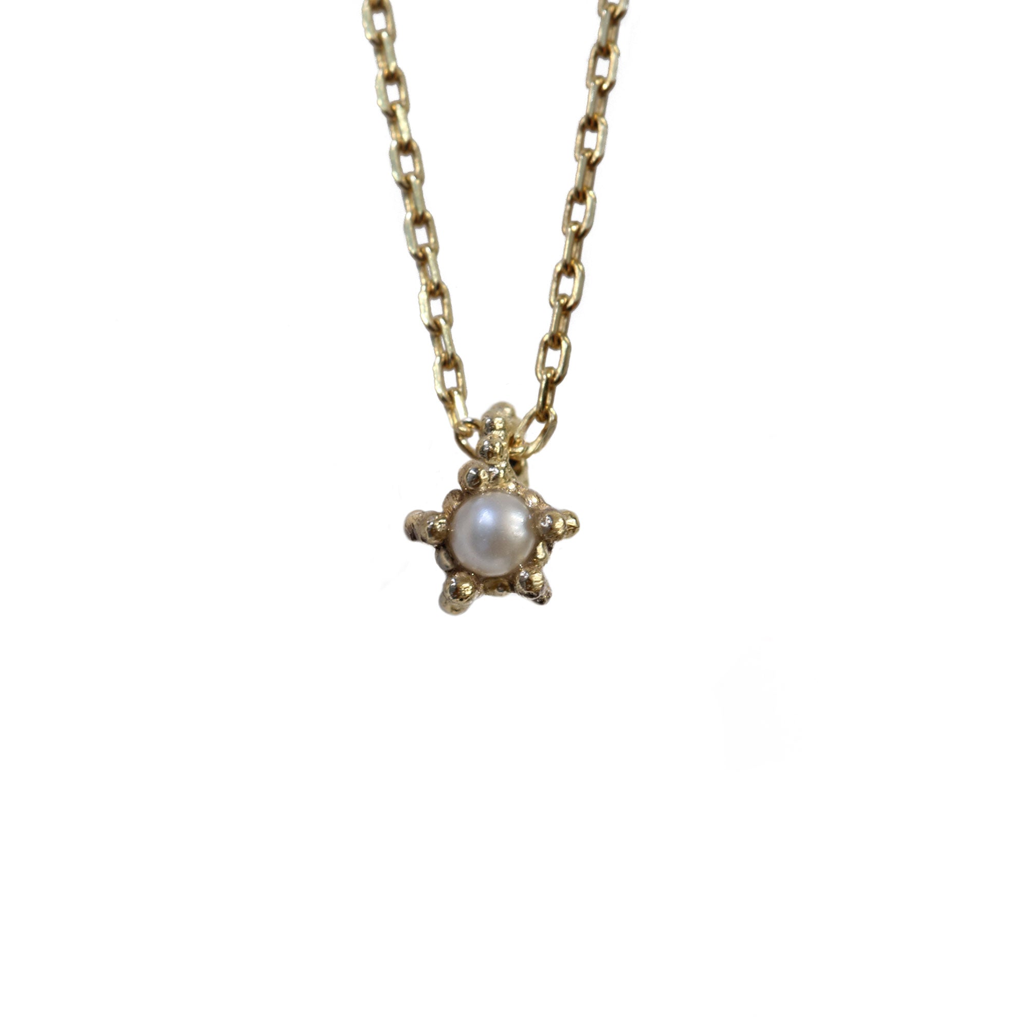 Tiny pearl textured gold necklace on white background