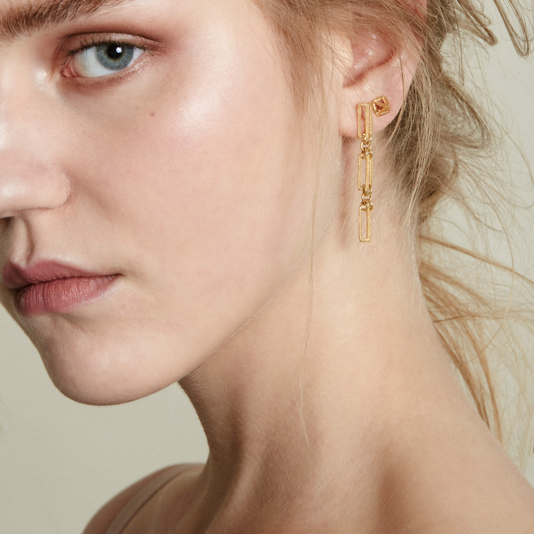 A model wearing a Maxilla Link yellow gold drop earring
