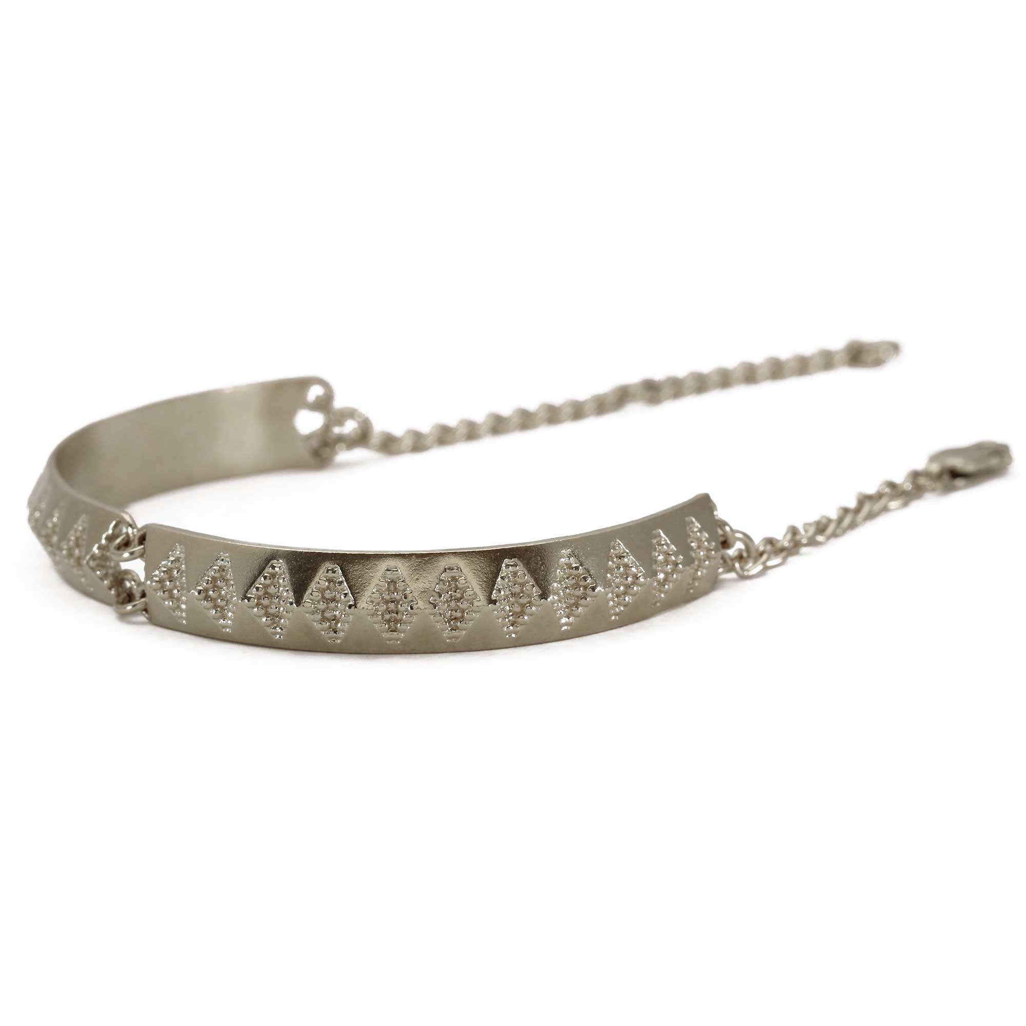Silver bangle bracelet with repeating diamond imprint on white background 