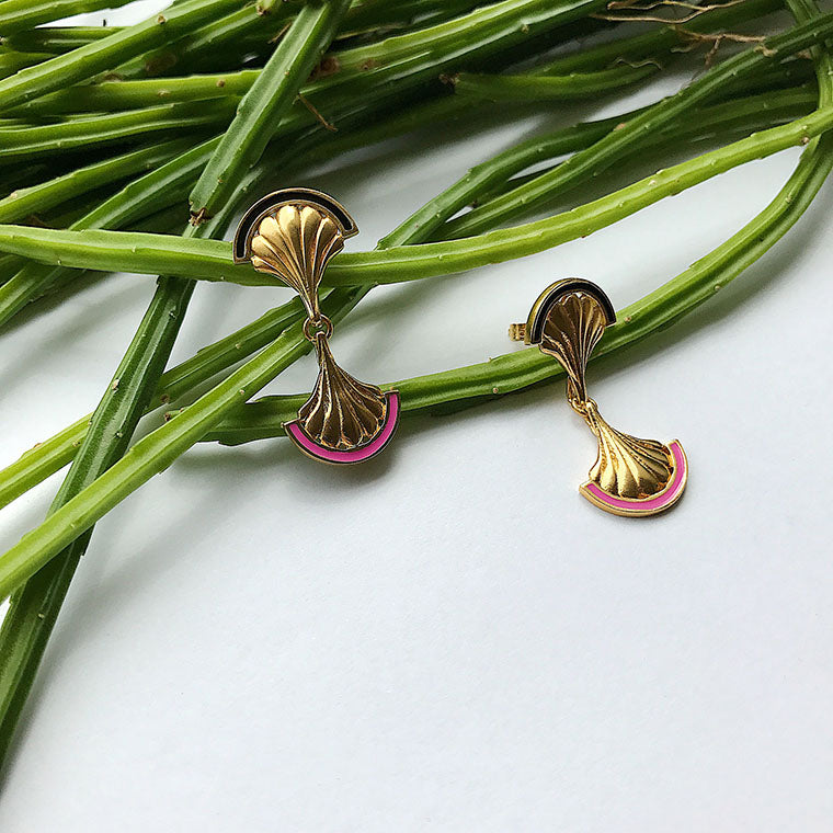 A pair of gold shell drop earrings with black and pink enamel crescents