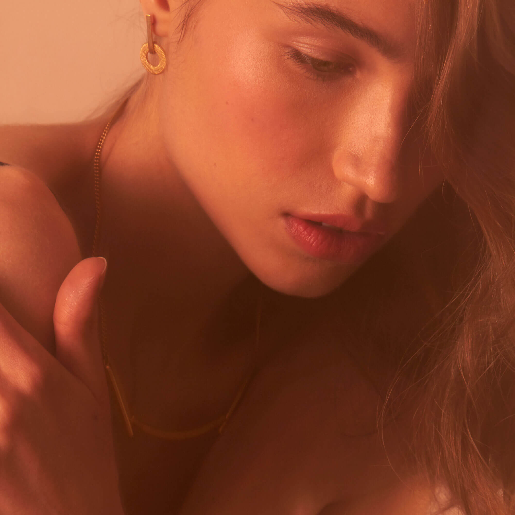 A model wearing a textured gold drop earrings