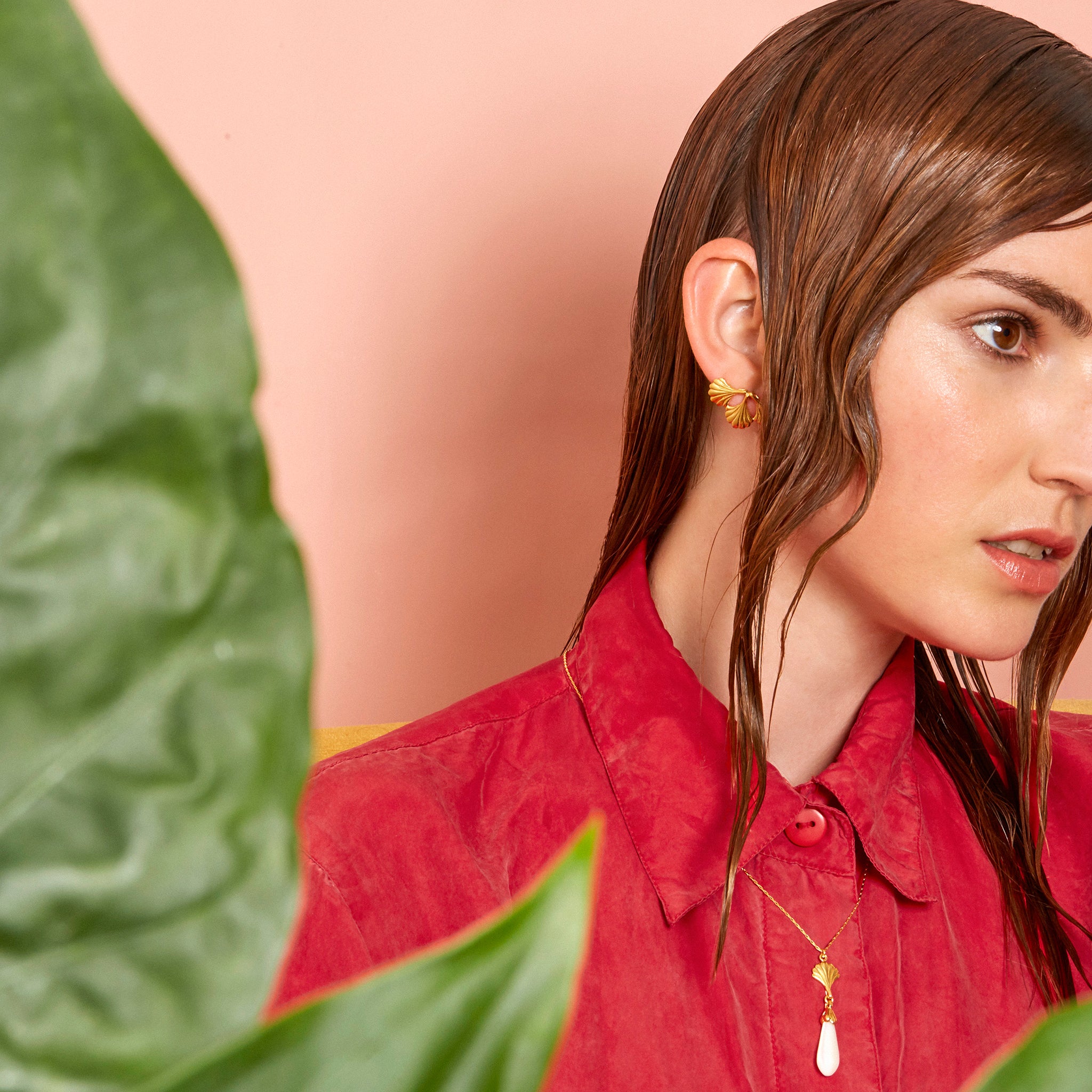 Model in red blouse wearing yellow gold necklace