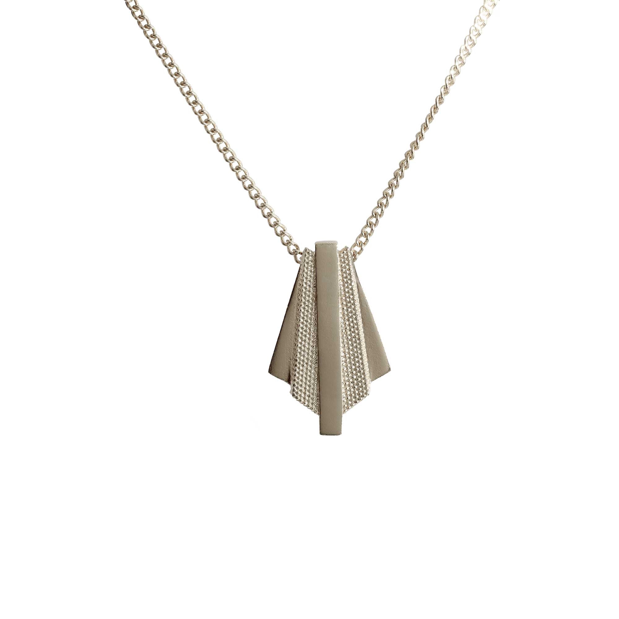 The contrasting rough and smooth textures of the Ruptus Slab geometric necklace in sterling silver