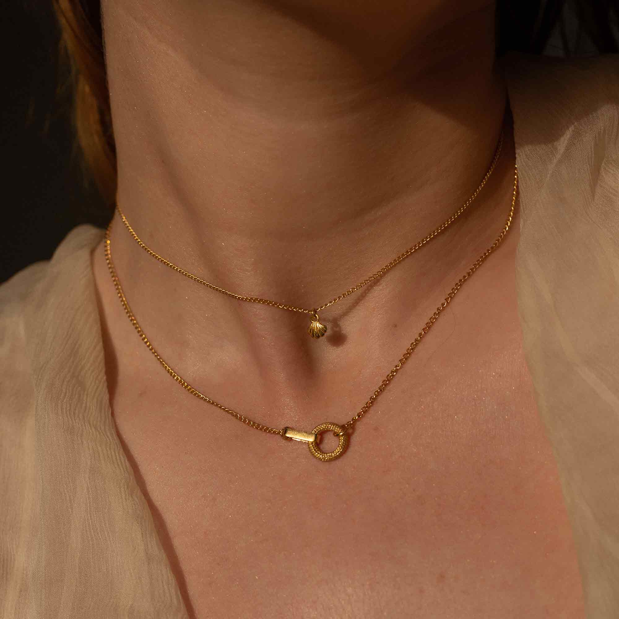 Model wearing 2 necklaces, one is the Tiny Wing gold shell necklace