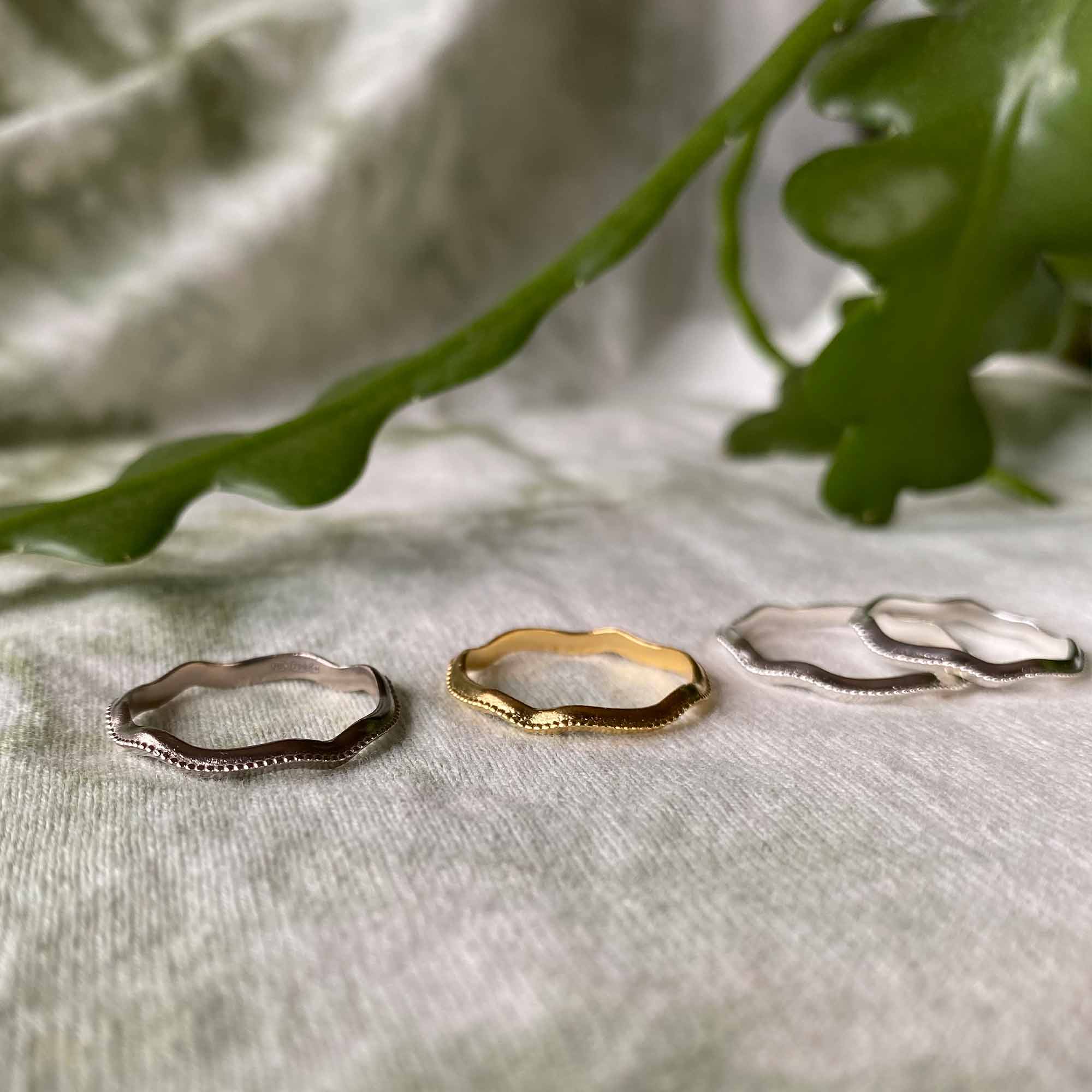 4 gold and sterling silver wiggly rings with single milgrain bead running across the centre