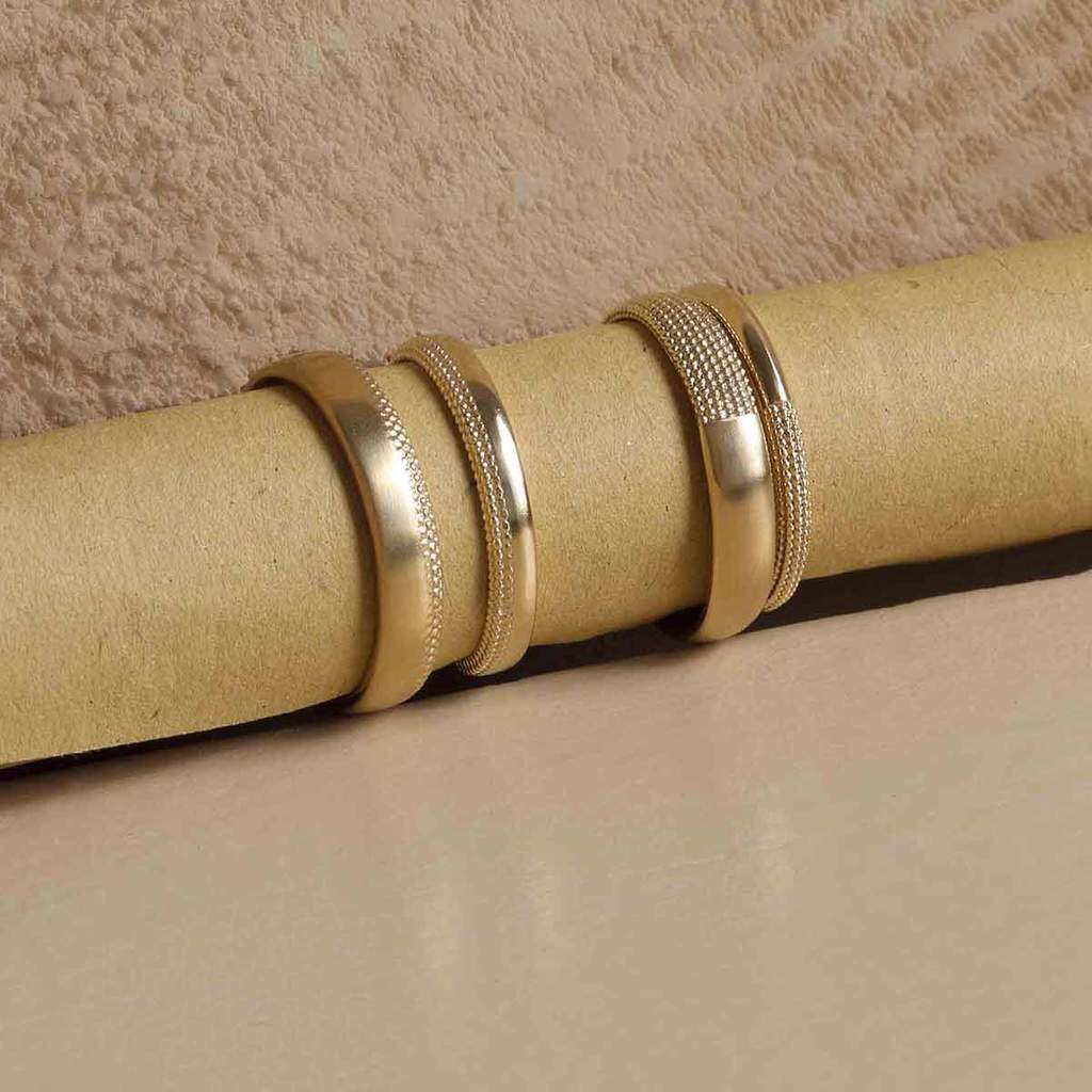 4 yellow gold rings with milgrain texture detailing on recycled paper roll