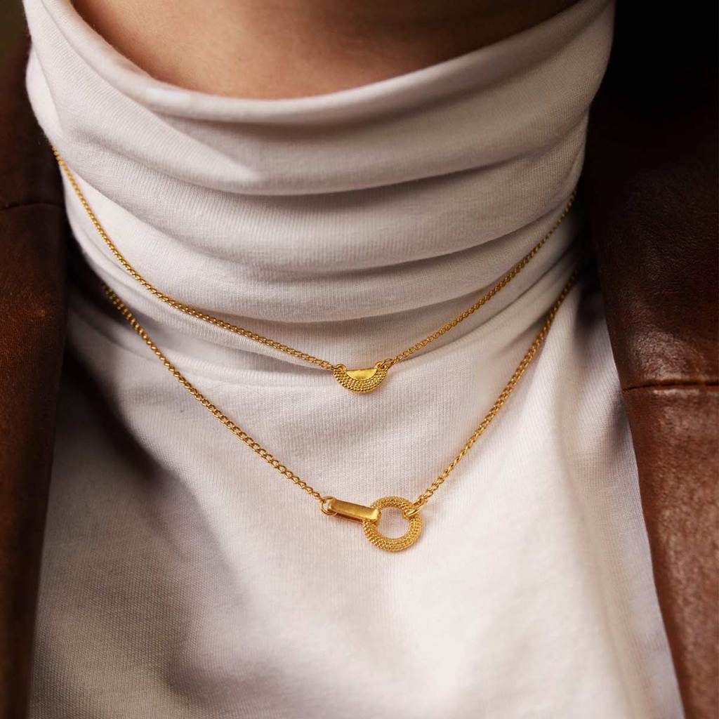 2 gold short chain necklaces on model over roll neck