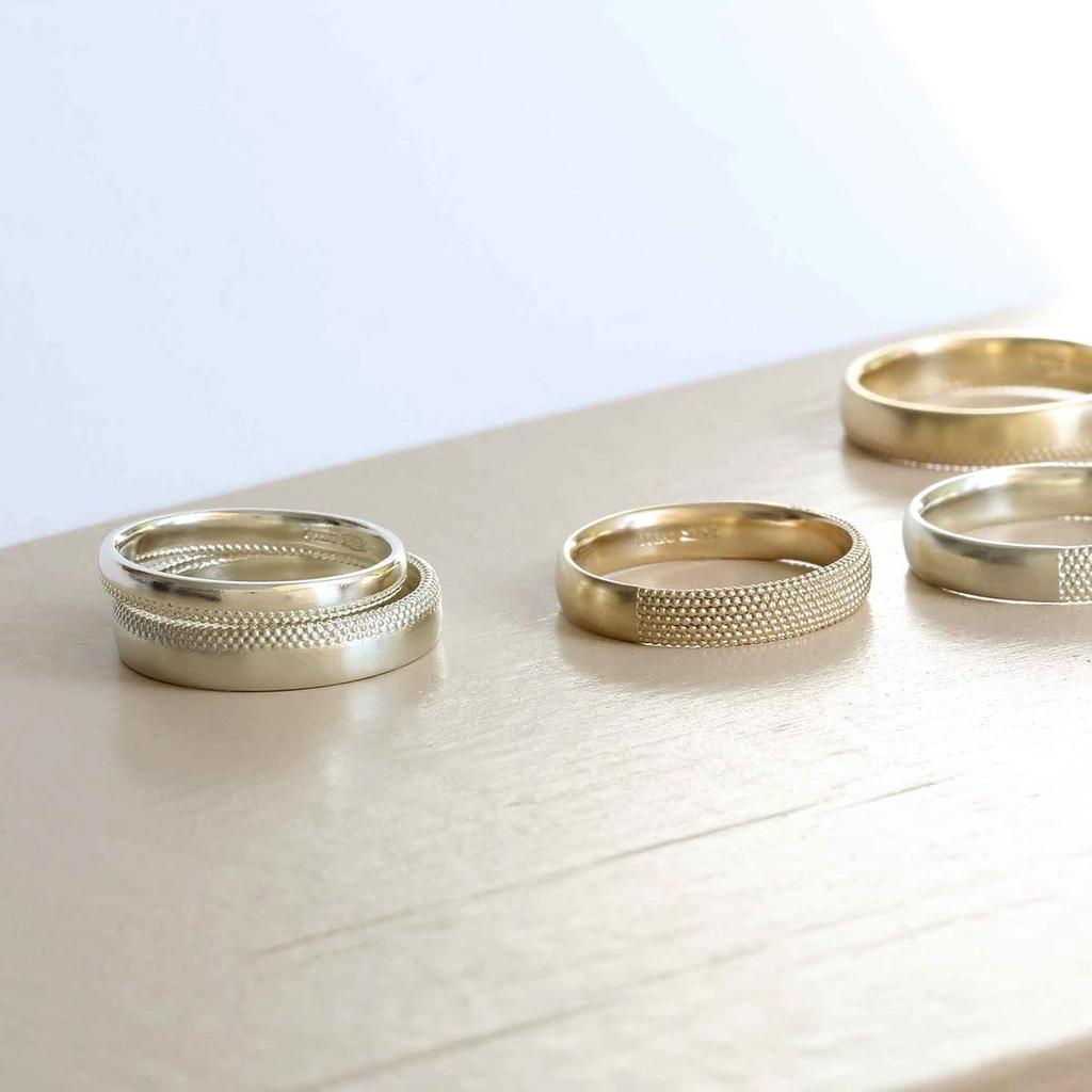 A selection of textured white gold rings on a table top